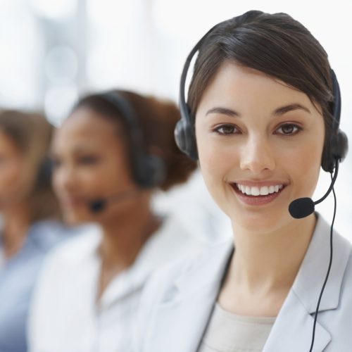 Closeup of a call center employee with headset at workplace